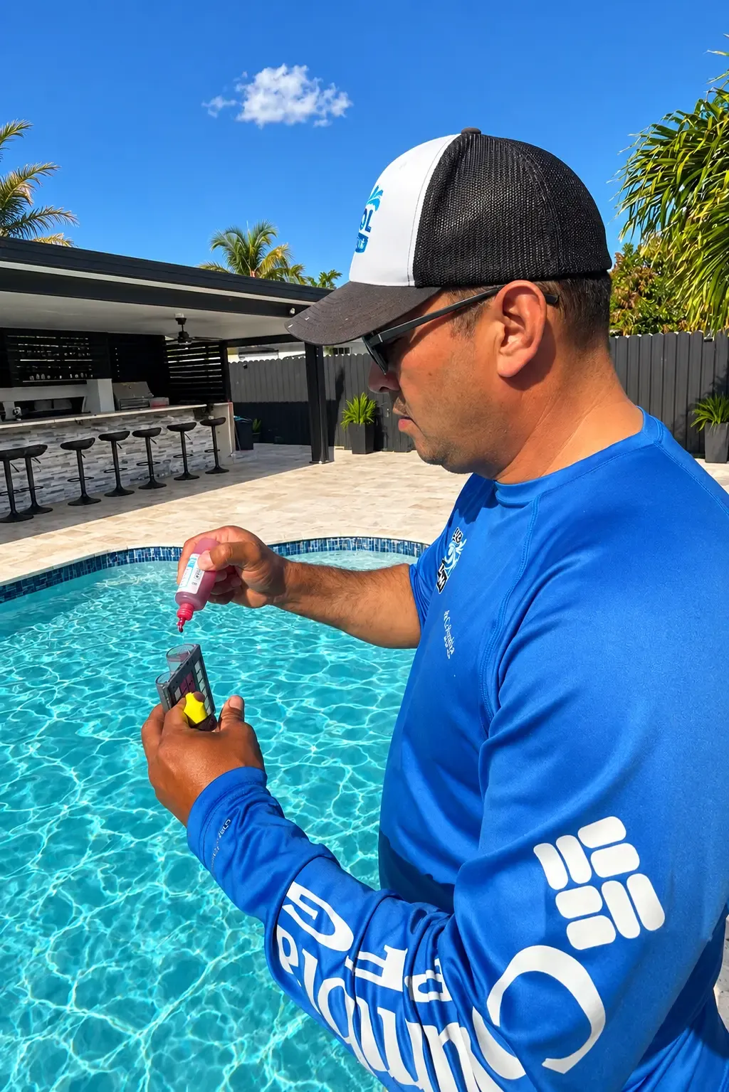 Technician adding reagent to a test kit to check a pool’s chlorine and pH levels